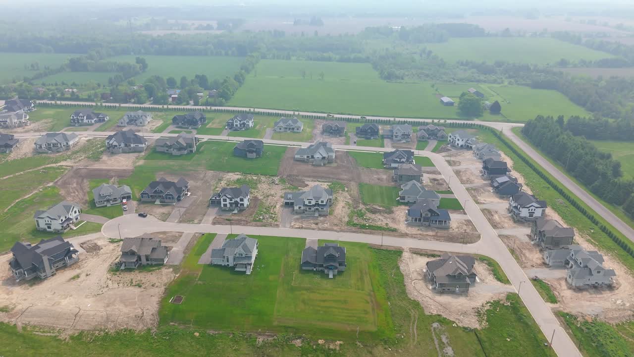 Suburban housing development expansion with wildfire smoke or atmospheric haze, aerial