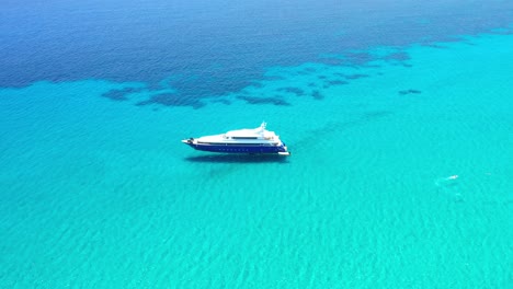 Still-yacht-in-crystal-clear-turquoise-water-during-a-sunny-day