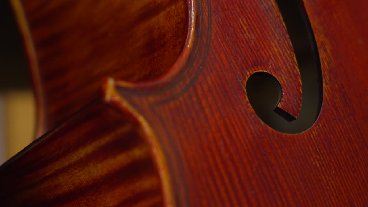 Close-Up View of a Beautifully Crafted Brown Cello with a Resting French Bow