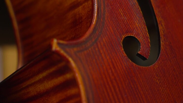 Close-Up View of a Beautifully Crafted Brown Cello with a Resting French Bow