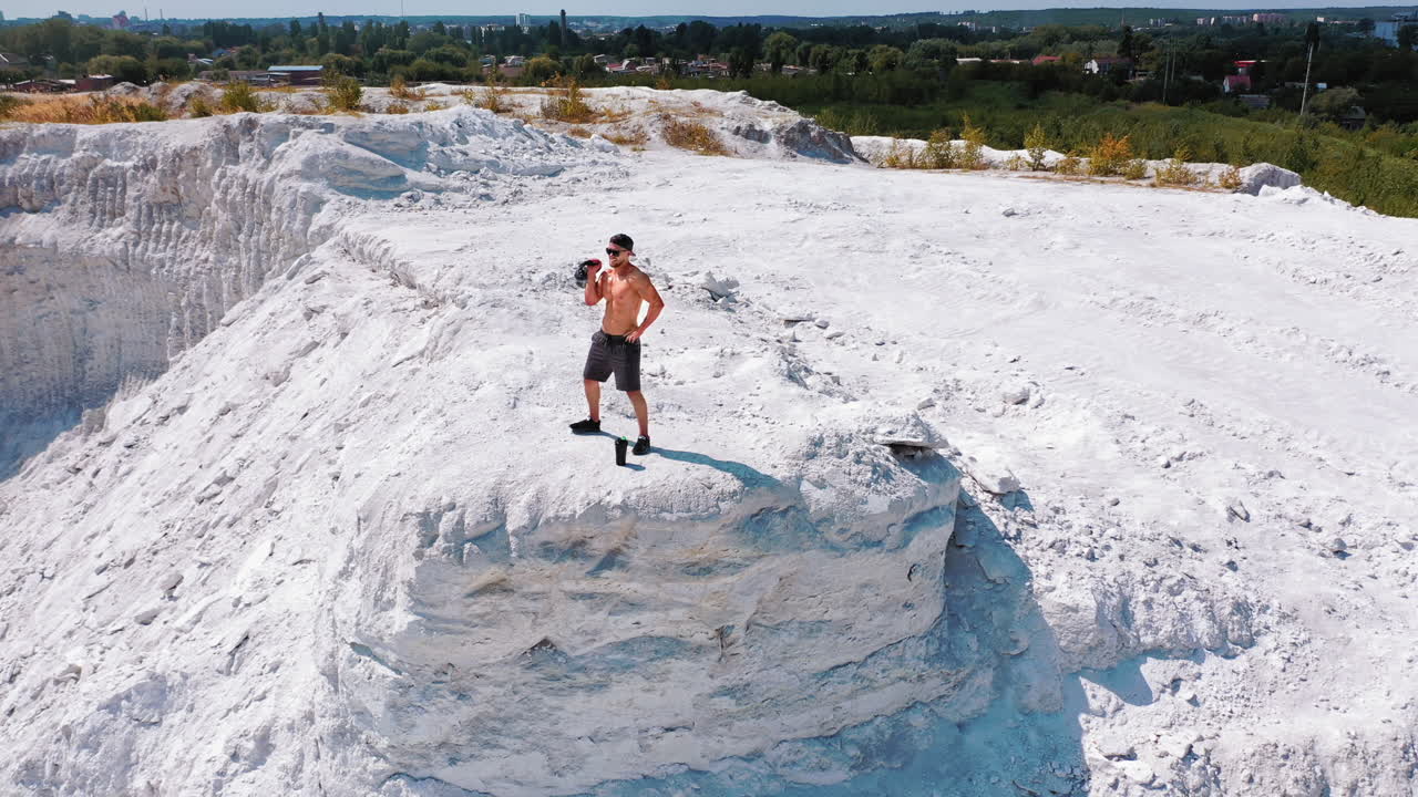 Brutal strong bodybuilder pumping up muscles. Bodybuilding and outdoor sports concept. Aerial view.