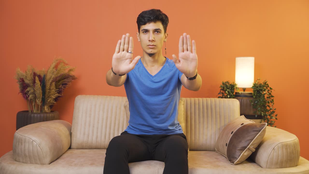 남자가 카메라를 위해 정지 표지판을 만들고 있습니다.