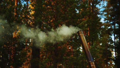 insulated wood stove chimney belching smoke at autumn forest camp