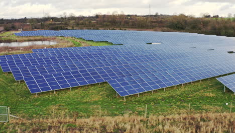 A-solar-farm-in-Staffordshire,-thousands-of-Solar-Panels-capturing-the-sun's-natural-light-and-converting-it-into-renewable,-sustainable-energy-due-to-the-ongoing-climate-change,-natural-energy