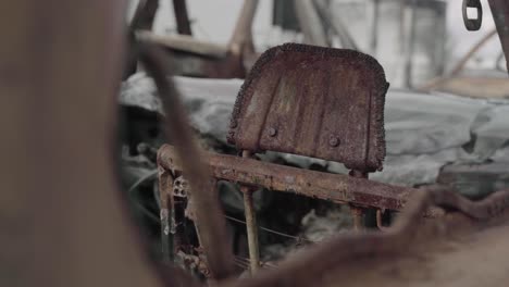 the rusted metal frame of the back of a car seat headrest - aftermath of a car wreck in a wildfire - 4k