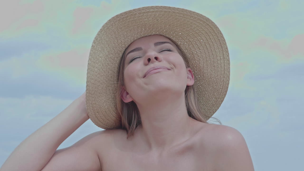 Tilt up shot showing beautiful young girl at beach enjoying the sun,close up