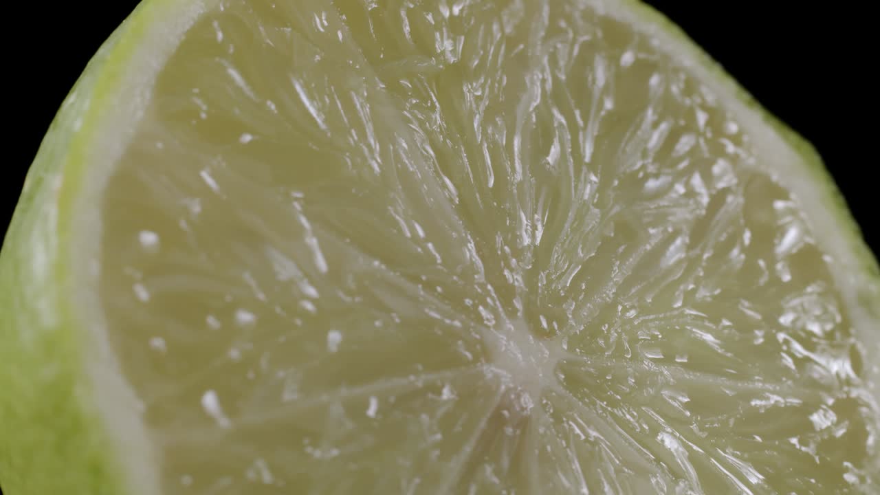 video de limón verde en rodajas sobre un fondo negro