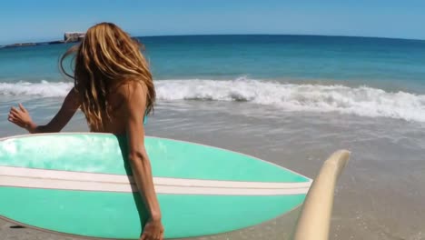 Woman-running-with-surfboard-on-beach