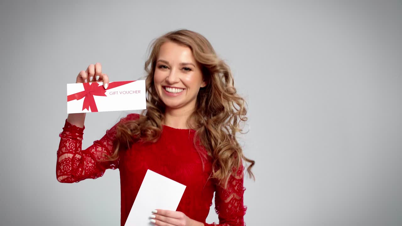 chica emocionada mostrando una tarjeta de regalo