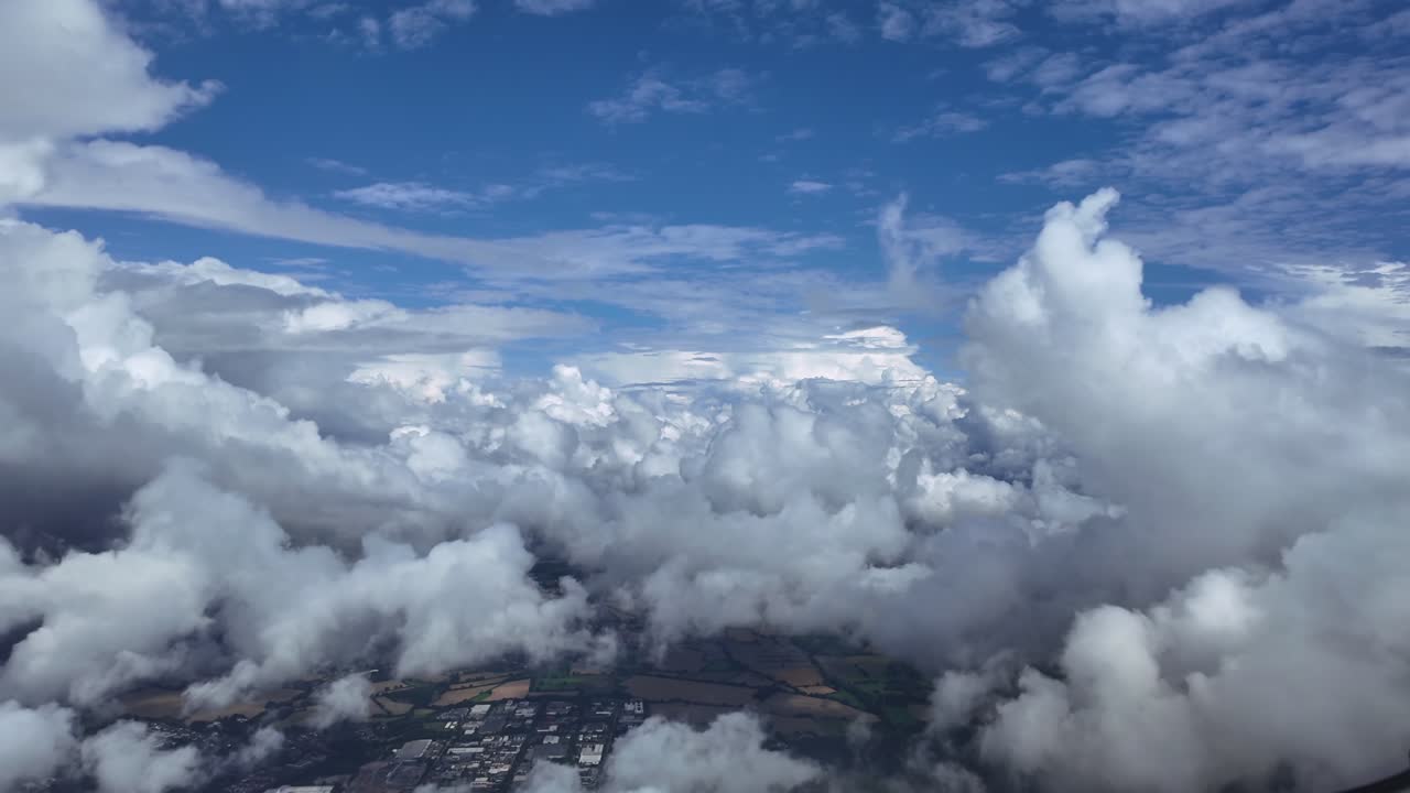 An immersive pilot’s view from the cockpit of a jet flying peacefully through white cottony cumulus clouds under a blue sky. Aerial ultra-realistic 4K shot