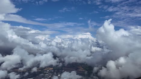 an immersive pilot’s view from the cockpit of a jet flying peacefully through white cottony cumulus clouds under a blue sky. aerial ultra-realistic 4k shot
