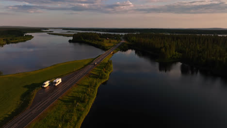 Vista-Aérea-Siguiendo-Un-Coche-Conduciendo-Por-La-Carretera-E75,-Atardecer-De-Verano-En-Laponia