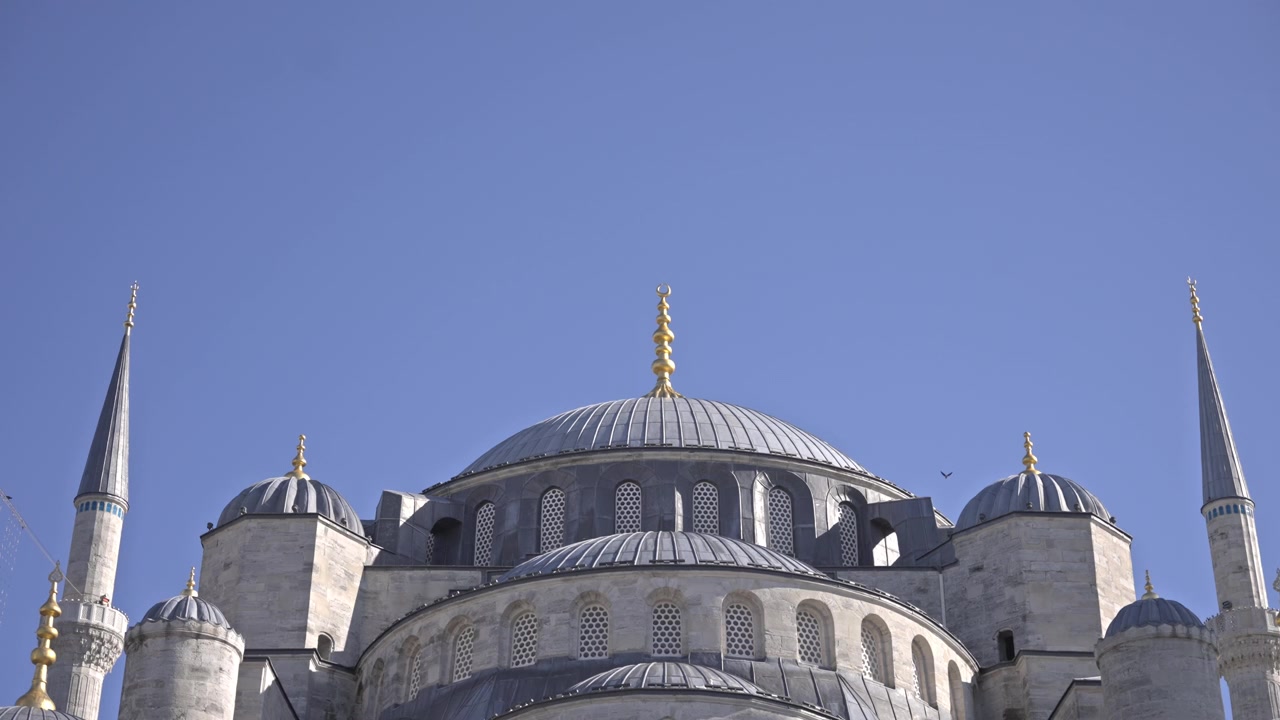Filmato cinematografico in 4K dell'esterno della Moschea del Sultano Ahmed (Moschea Blu), che mostra le sue cupole a cascata, sei minareti e il cortile ad arco. Cielo azzurro limpido, Istanbul, Turchia.