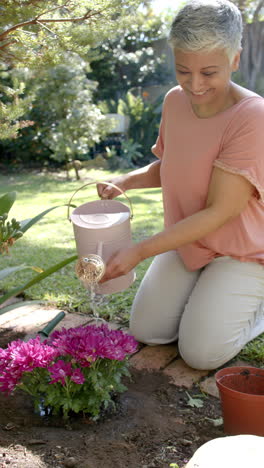 vertical video of portrait of happy senior biracial woman working in garden, slow motion