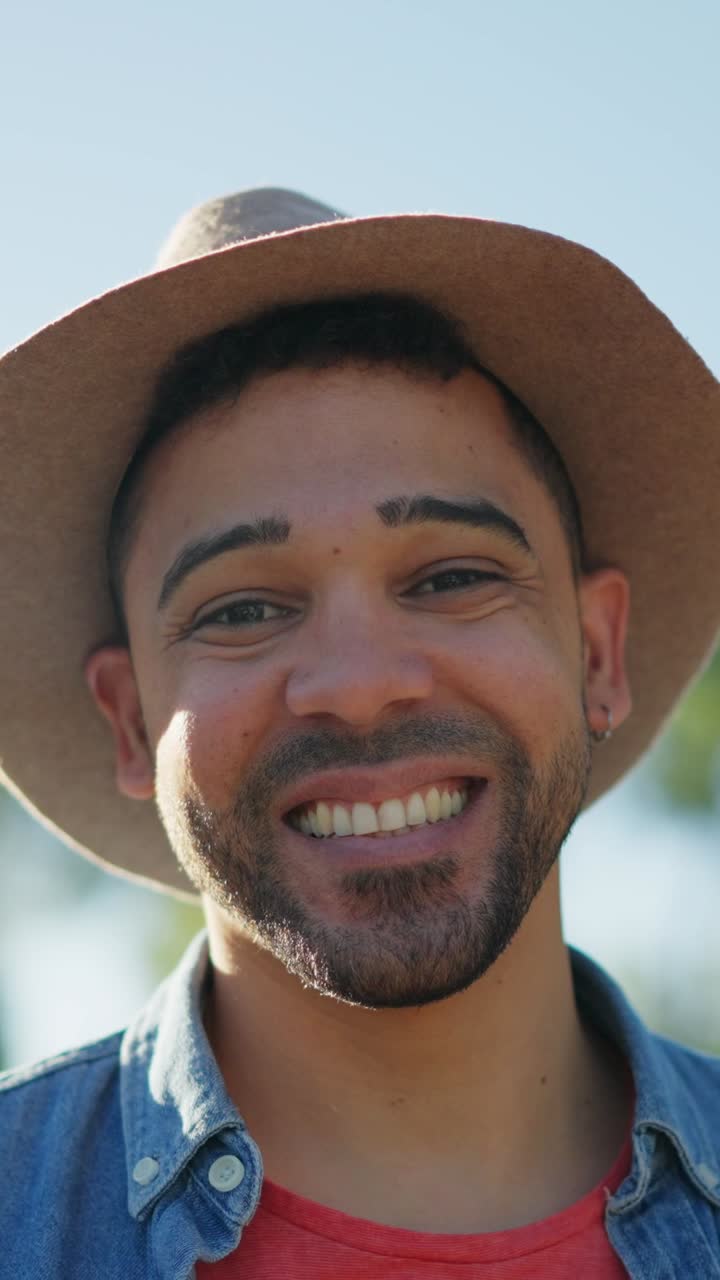 retrato en primer plano de un hombre sonriente con un sombrero