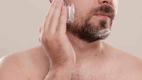 man shaving his beard