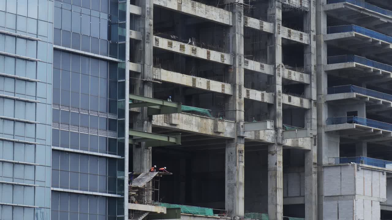 edificio en construcción en yakarta con trabajadores supervisando el sitio desde varios pisos con sede en indonesia