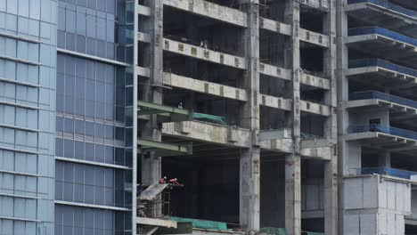 building under construction in jakarta with workmen overseeing the site from various floors based in indonesia