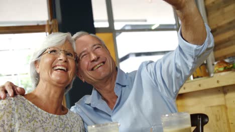 senior couple taking a selfie in the cafe 4k