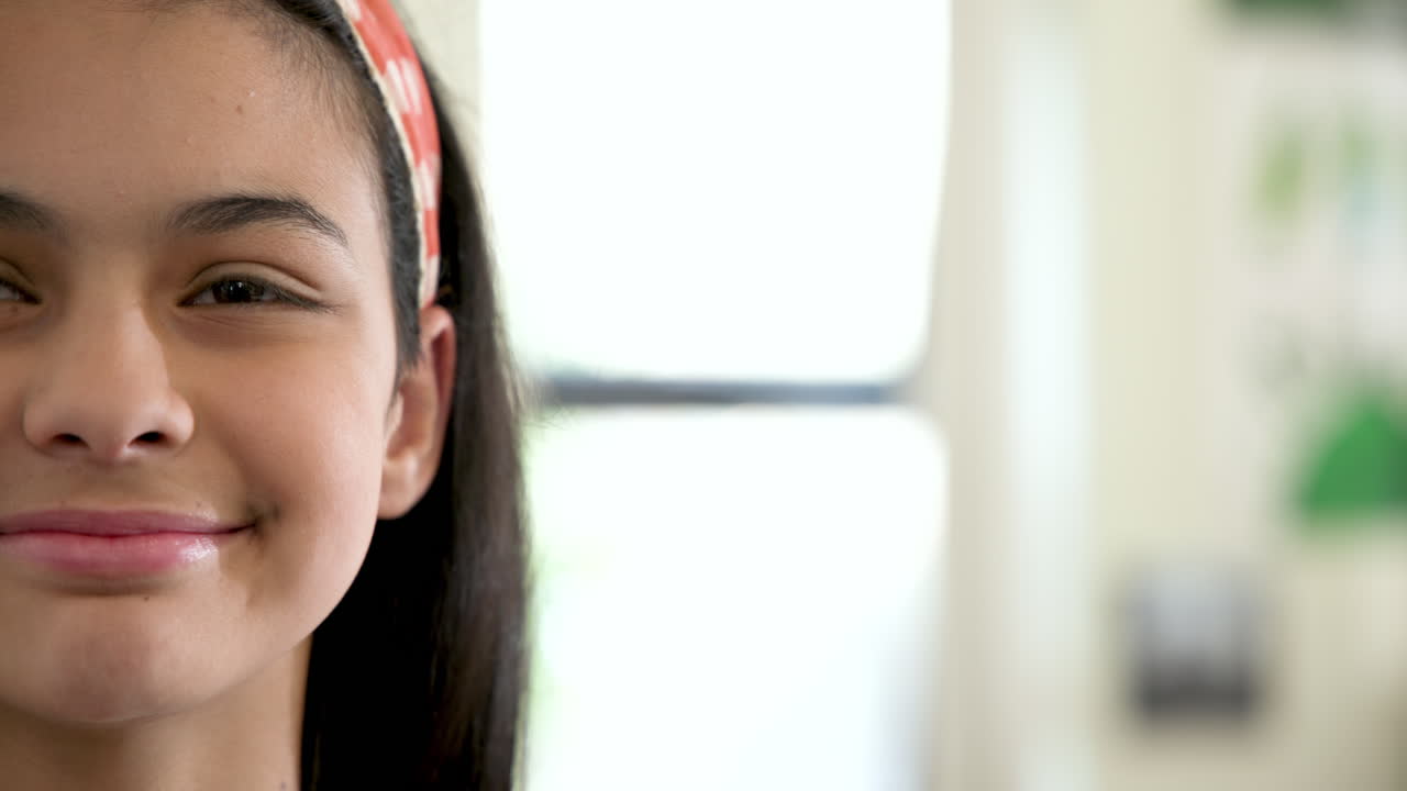 In school, girl wearing headband smiling and enjoying classroom environment, copy space