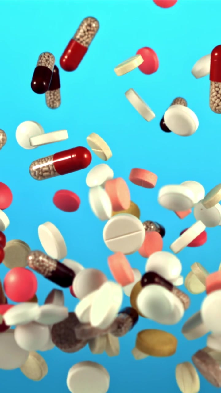 Assorted Pills and Capsules Falling and Rising in Slow Motion