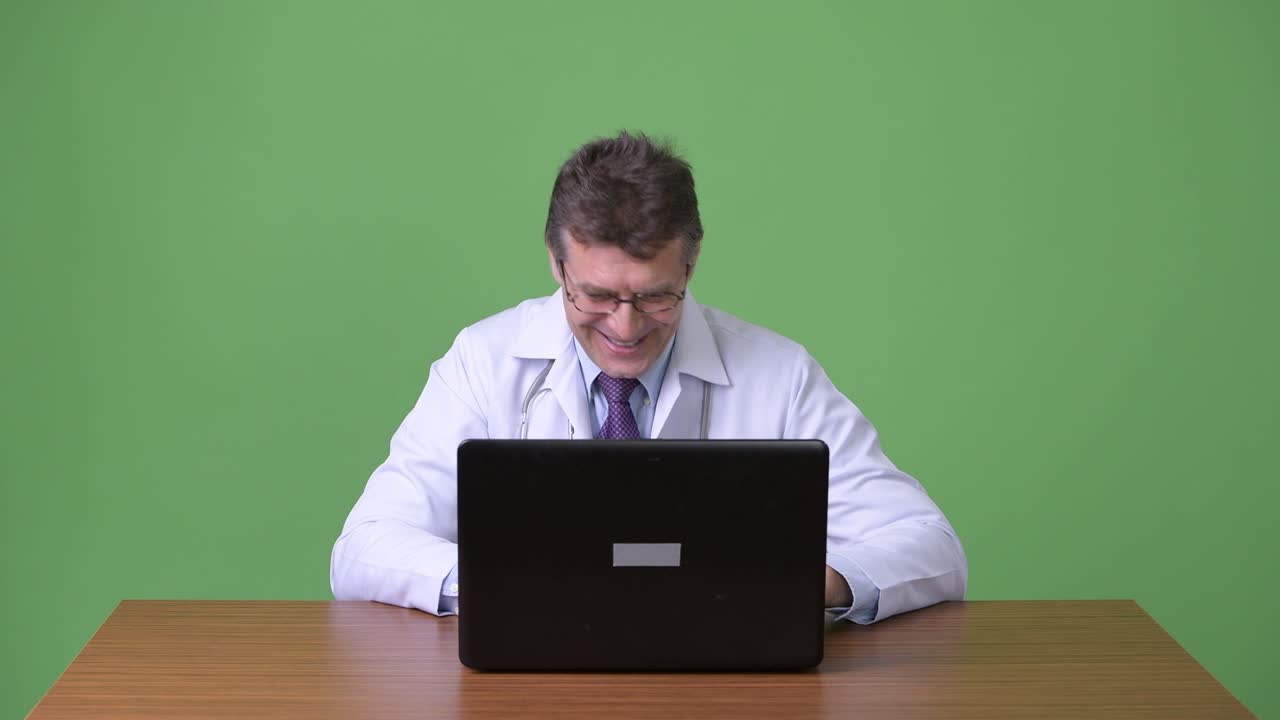 hombre maduro y guapo médico contra fondo verde