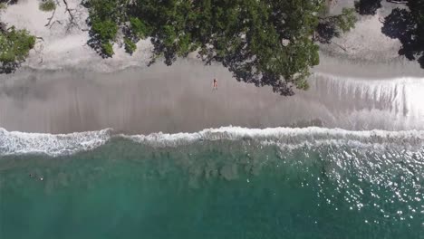 Vista-De-Drones-De-Una-Niña-Acostada-En-Una-Playa-Paradisíaca-En-Costa-Rica