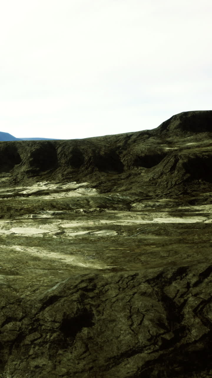 Rocky landscape in a volcanic region with distant mountains in the background