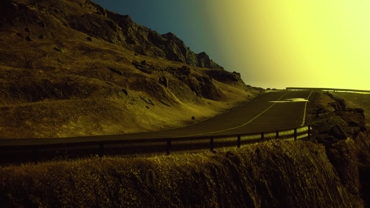Curving mountain road under bright sun setting near rocky landscape