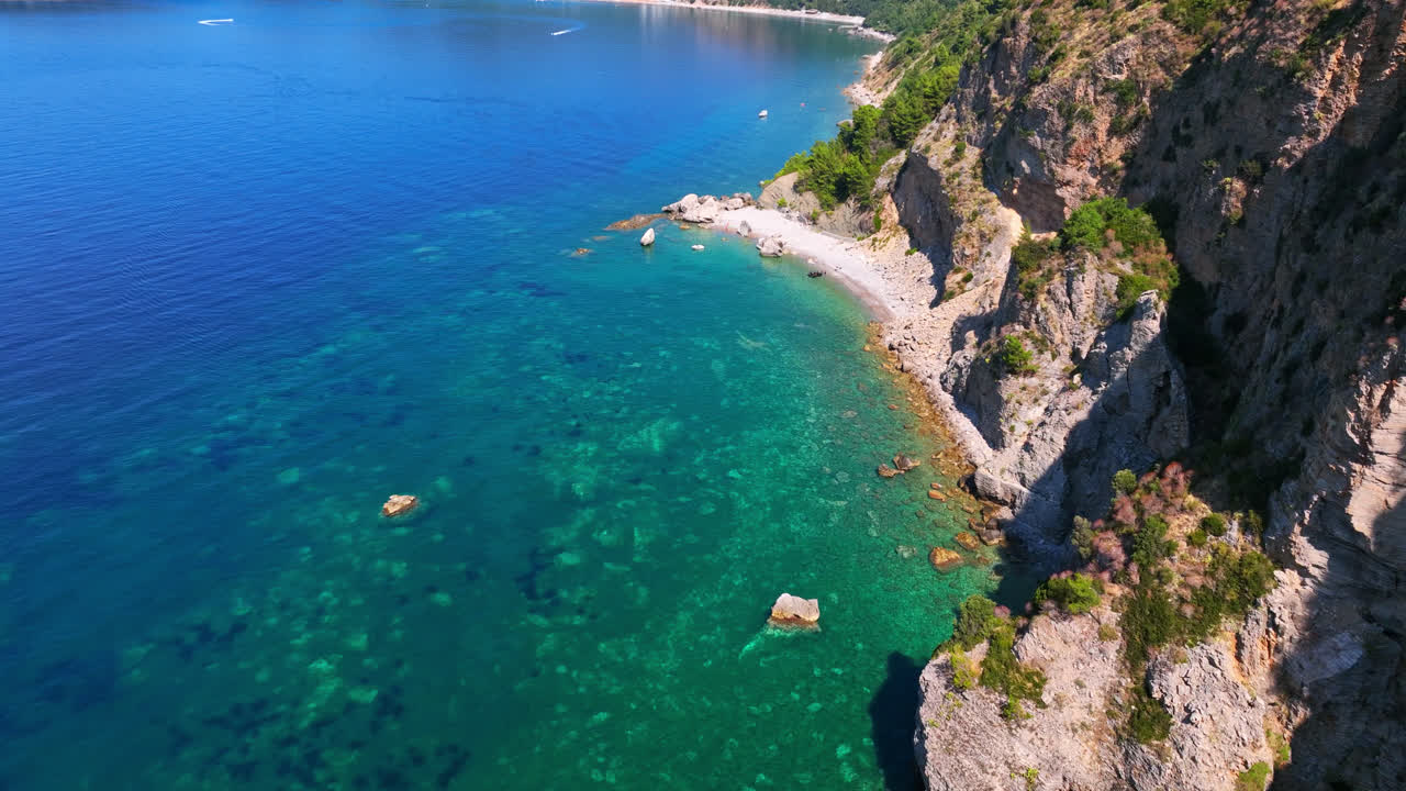 Aerial view of blue sea and the rocky Beach Calypso, summer in Budva, Montenegro