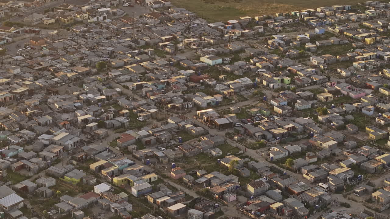 Ciudad del Cabo, Sudáfrica. Vuelo aéreo v103 con zoom y alrededor del municipio de Khayelitsha, capturando asentamientos informales superpoblados en la zona al atardecer. Grabado con Mavic 3 Pro Cine - 11 de enero de 2024