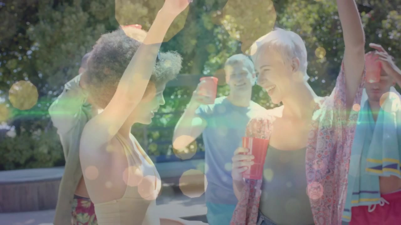 To venner udveksler blikke, danser på pooldækket, mens en gruppe skåler, bokeh over røde kopper til en begivenhed