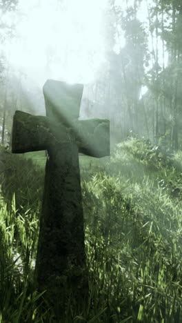 stone cross in a foggy forest