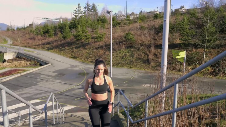 Fit ung kvinde, der løber op ad trapper og træner. Slowmotion