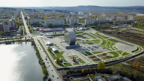 aerial view of a modern city with a unique building and park