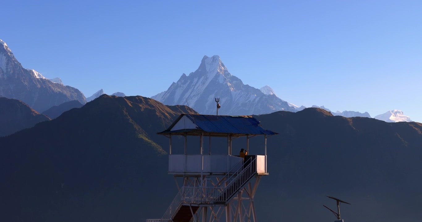 Regione dell'Annapurna, Poon Hill, Nepal: Ripresa aerea dalla torre di osservazione che rivela l'iconica cima innevata del Machhapuchhre sotto imponenti colline.