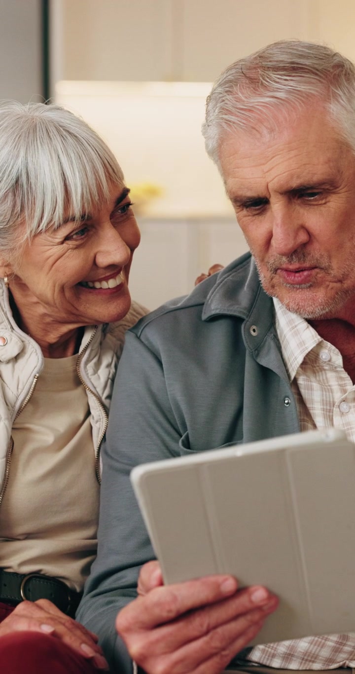 Casal de Idosos Feliz Usando um Tablet Juntos em Casa