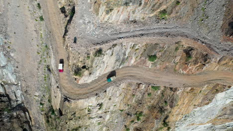 impresionante toma de drones de vehículos remolcadores que se acercan a una curva en fairy meadows road en pakistán, la segunda carretera más mortífera del mundo, toma aérea en ángulo descendente