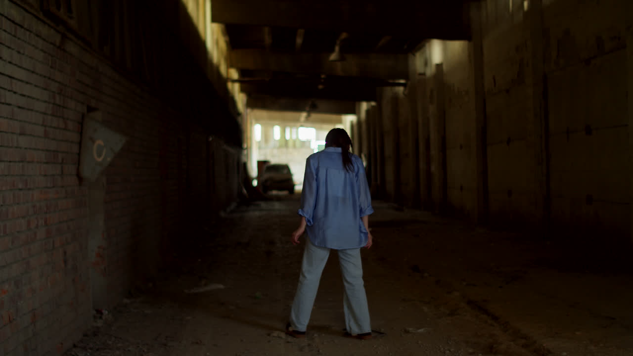 Woman Walking Through an Abandoned Industrial Building