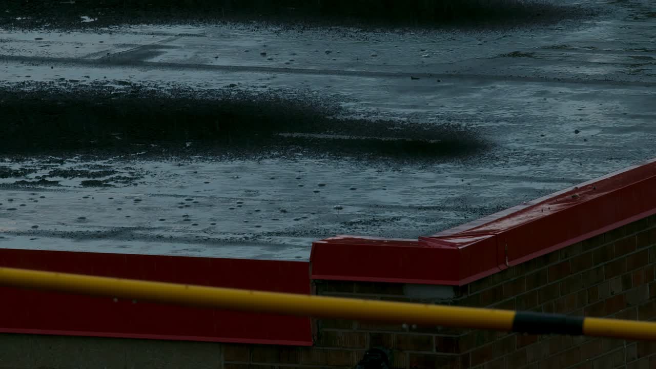 아파트 건물 지붕에 아지는 비가 느린 속도로 아지고 있다.