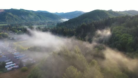 aerial view of fog above campground, evergreen forest and landscape near forks city, washington state