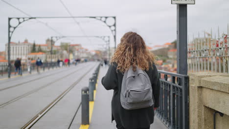 woman walking on a bridge in a city