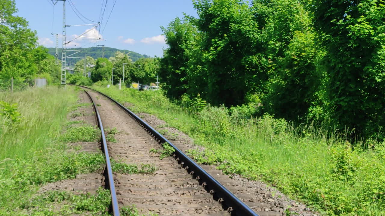 Train tracks in rural Germany connecting the cities of Loerrach Germany and Basel in Switzerland. Slow zoom in shot.