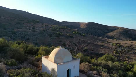 sunset's golden embrace over a saint's tomb, seen from above, where the righteous find eternal rest and peace