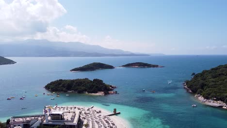 Drone-footage-showcasing-the-stunning-azure-waters,-sandy-beaches,-and-picturesque-islands-of-Ksamil,-Albania