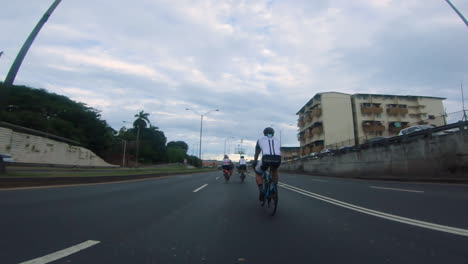 a group of cyclists riding on the open road in panama