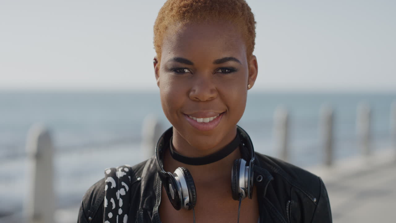ritratto giovane donna afroamericana fiduciosa sorridente che gode di uno stile di vita indipendente studentessa nera alla moda che sembra felice sul mare sullo sfondo dell'oceano