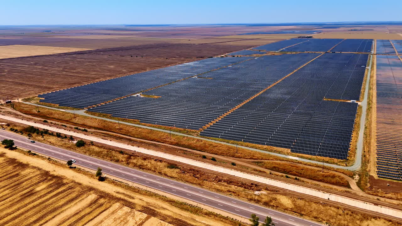 Highways along the fields with solar panels. Drone flight over the countryside landscape used for green energy production