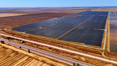 Highways along the fields with solar panels. Drone flight over the countryside landscape used for green energy production