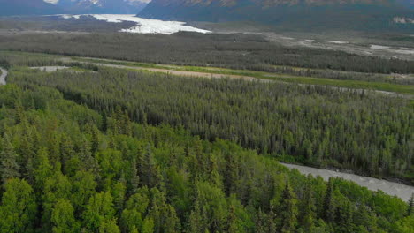 Muddy-raging-Matanuska-River-aerial-reveal-with-mountains-in-Alaska-forest